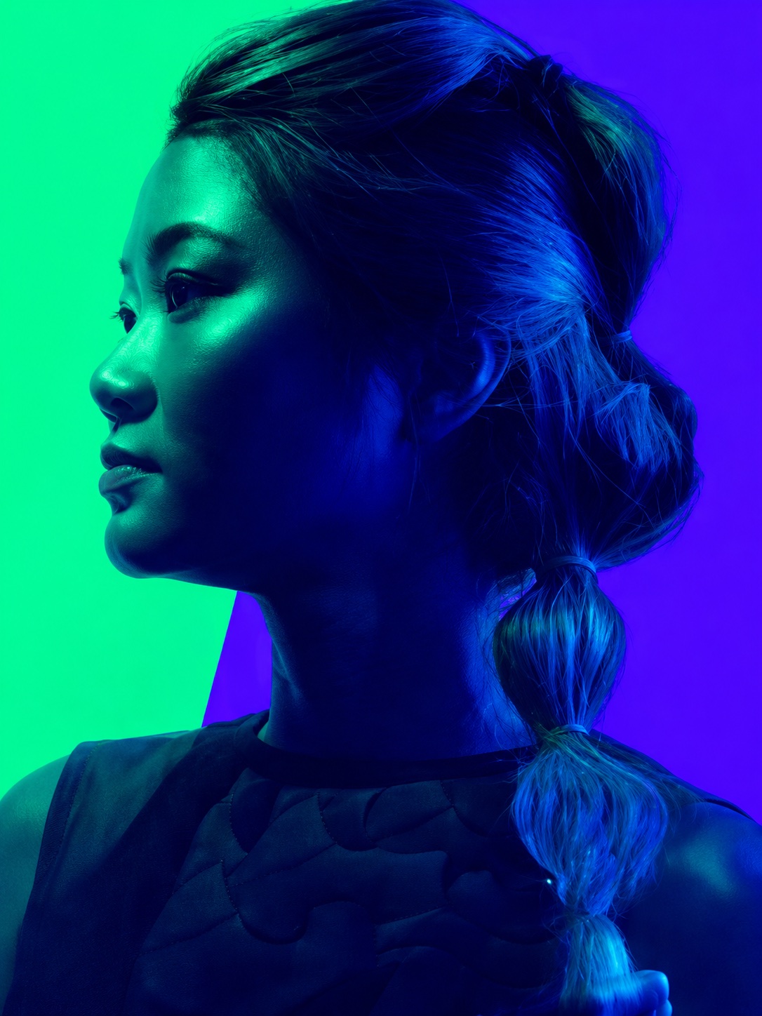 A face lit half green, half blue